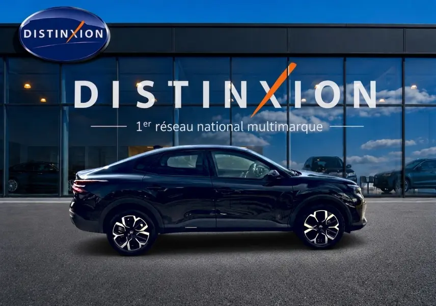 Profil côté gauche d'une Citroën C4 X noire 2025, avec jantes alu et silhouette élancée devant une vitrine Distinxion.