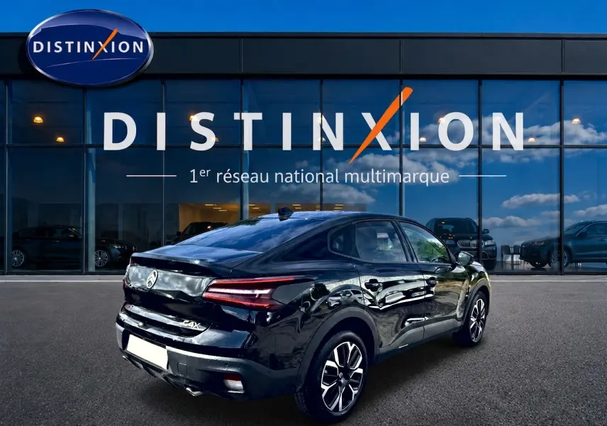 Vue 3/4 arrière droite d'une Citroën C4 X noire 2025 avec feux arrière LED et jantes alu distinctives.