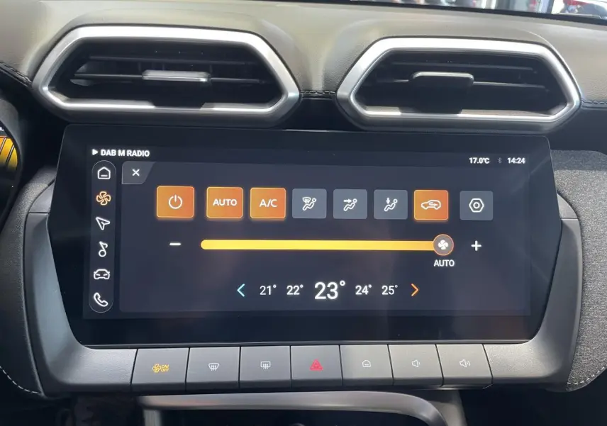 Écran tactile central du MG Motor ZS 1.5 Hybrid+ 2026, affichant la climatisation automatique, entouré de sorties d'air hexagonales.