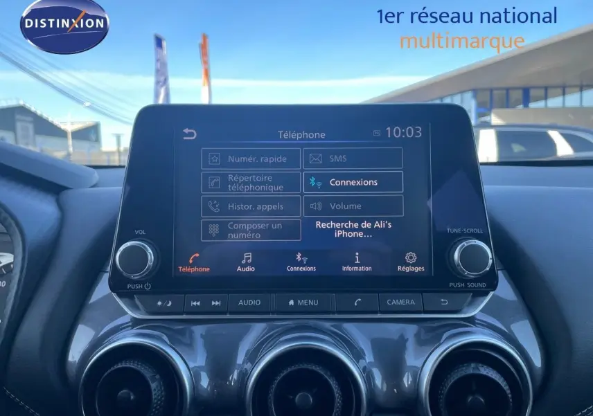Écran tactile central du tableau de bord du Nissan Juke gris squale métal 2024, affichant le menu téléphone et connexions Bluetooth.