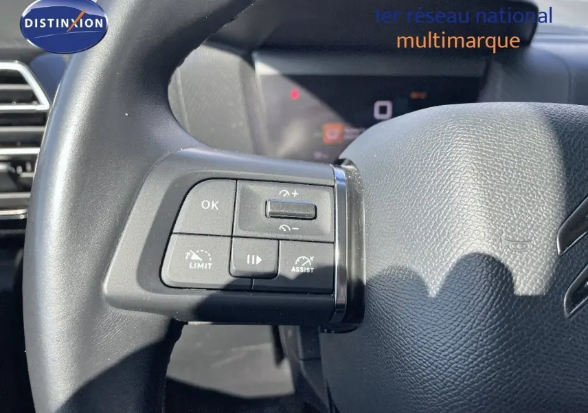 Gros plan sur le volant en cuir noir de la Citroën C4 avec commandes multifonctions à gauche visibles.