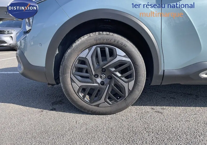 Gros plan sur la roue avant gauche d'une Citroën C4 2021 bleu Iceland Metal avec jante noire au design moderne.