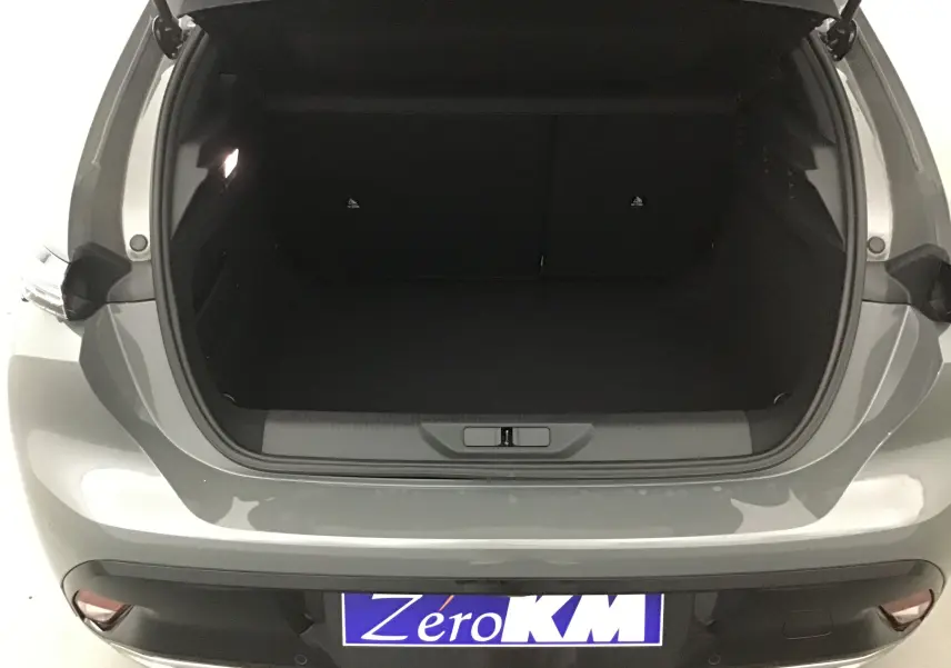 Coffre ouvert vu de l'arrière d'une Peugeot 308 gris selenium, montrant l'espace de chargement vide.