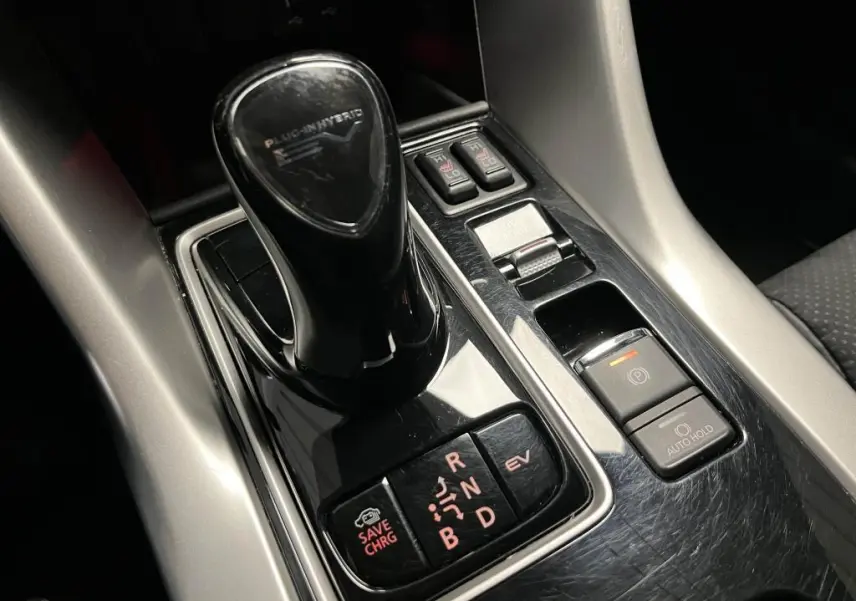 Le levier de vitesses noir brillant du Mitsubishi Eclipse Cross hybride rechargeable vu en gros plan sur la console centrale.