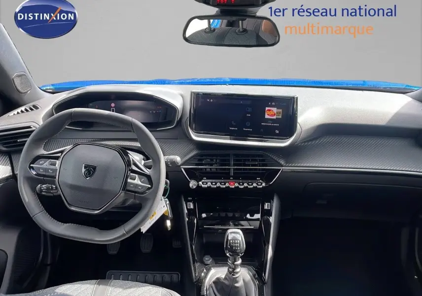 Intérieur du Peugeot 2008 2024 bleu Vertigo, vue frontale sur le tableau de bord et la boîte manuelle.