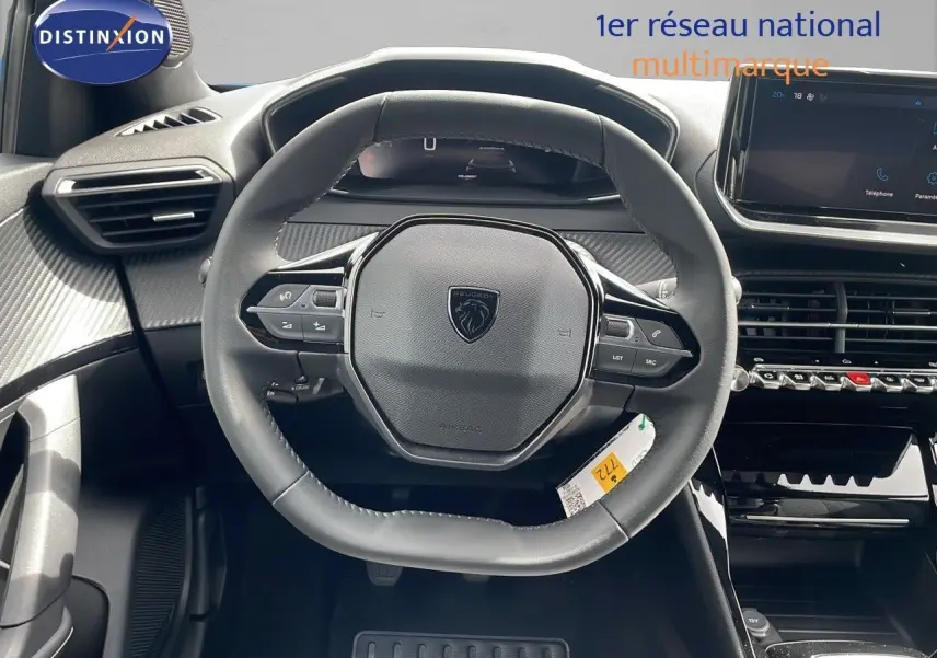 Vue rapprochée du volant multifonction noir du Peugeot 2008 2024 avec tableau de bord et écran tactile.
