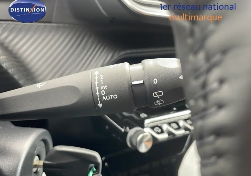 Gros plan sur la commande d'essuie-glace à gauche du volant dans l'habitacle du Peugeot 2008 bleu Vertigo Metal 2024.