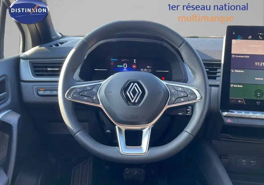Vue intérieure centrée sur le volant cuir perforé du Renault Captur E-Tech hybride 2025 avec tableau de bord digital.