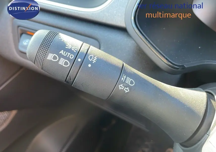 Gros plan sur la commande des phares et clignotants du Renault Captur E-Tech hybride blanc nacré, intérieur gris.