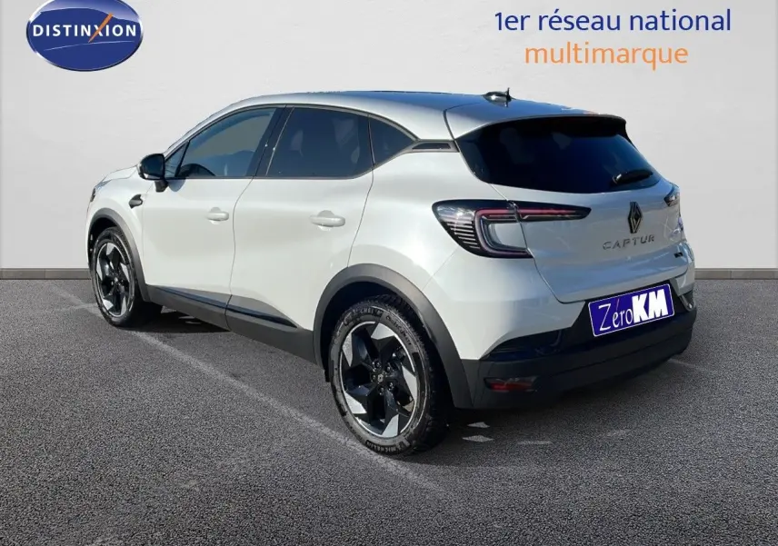 Vue 3/4 arrière gauche d'un Renault Captur blanc nacré avec toit gris et jantes noires distinctives.