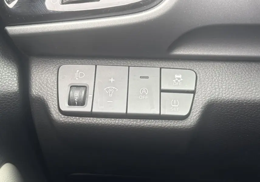 Gros plan sur les commandes de réglage d’éclairage et d’assistance du tableau de bord du Kia Stonic rouge 2020.