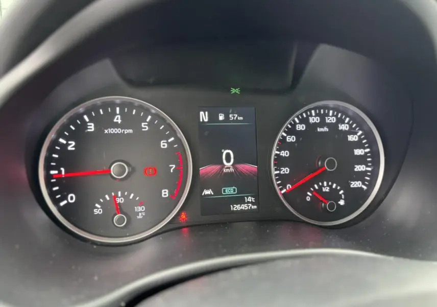 Vue rapprochée du tableau de bord du Kia Stonic rouge, affichant compte-tours, vitesse et écran central numérique.