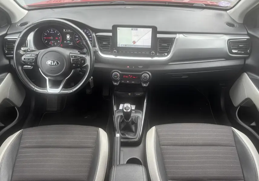 Vue intérieure frontale du tableau de bord et volant KIA Stonic avec écran tactile et boîte manuelle.