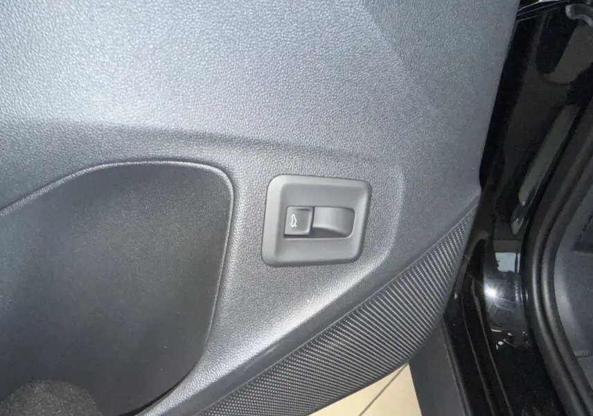 Détail de la portière arrière droite noire intense du Volkswagen T-Roc 2026 avec commande d'ouverture de coffre intégrée.