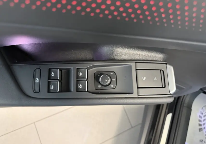 Gros plan sur les commandes de lève-vitres et réglage des rétroviseurs côté gauche du Volkswagen T-Roc noir intense 2026.