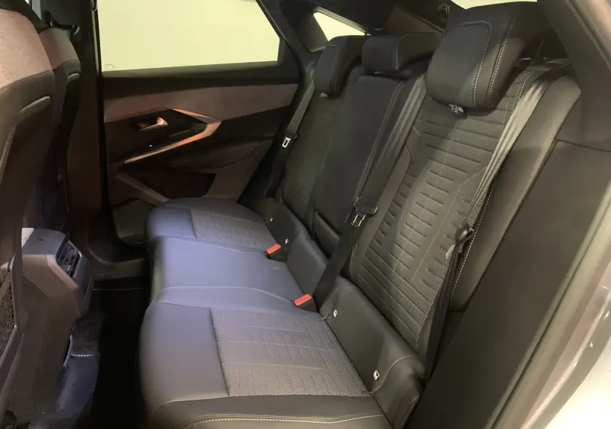 Vue intérieure côté droit des sièges arrière en cuir et tissu du Peugeot 3008 III GT Hybrid 136 gris Artense, avec ceinture et appuie-têtes.