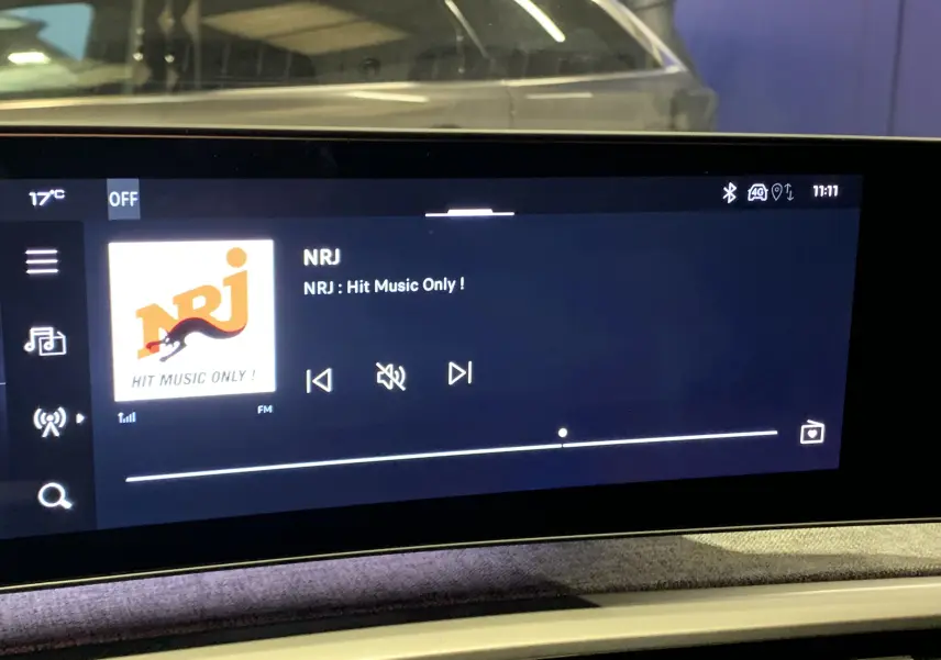 Écran multimédia intérieur du Peugeot 3008 III GT Hybrid 136 e-DSC6 affichant la radio NRJ, ambiance moderne et épurée.