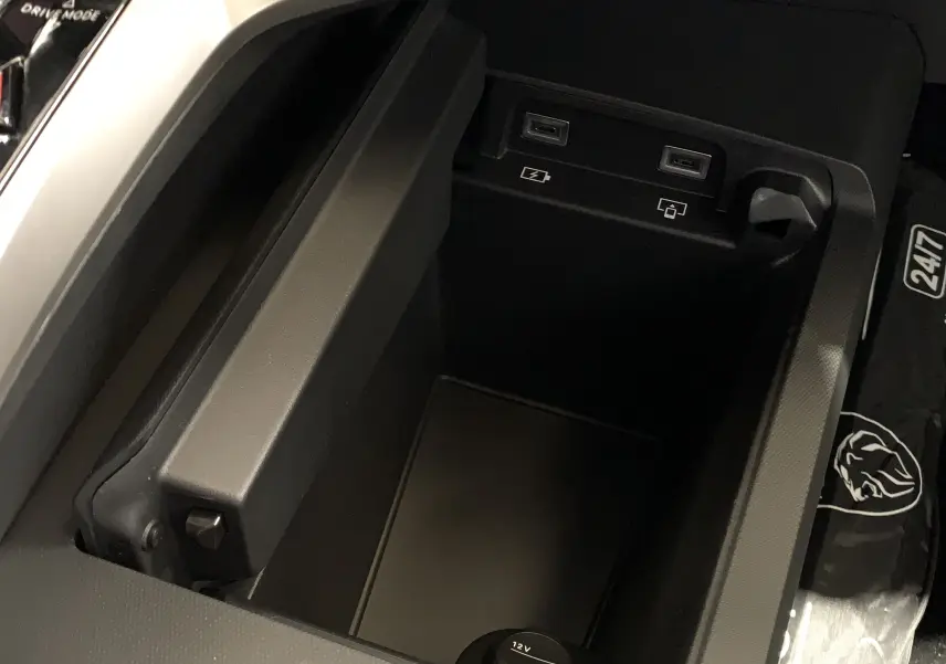 Vue rapprochée de la console centrale du Peugeot 3008 III GT Hybrid 136 e-DSC6 avec prises USB et prise 12V visibles.