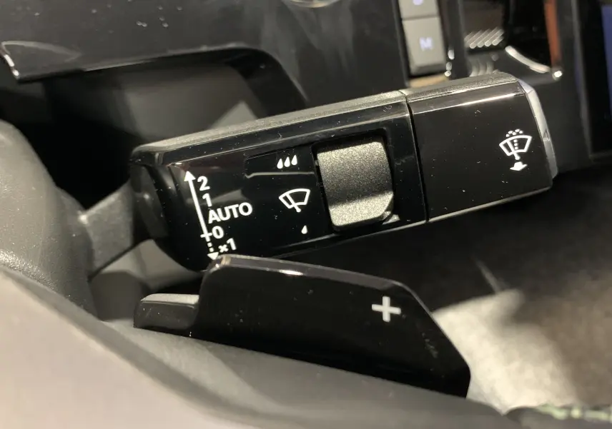 Gros plan sur la commande des essuie-glaces et la palette de changement de vitesse côté gauche du Peugeot 3008 gris Artense 2025.