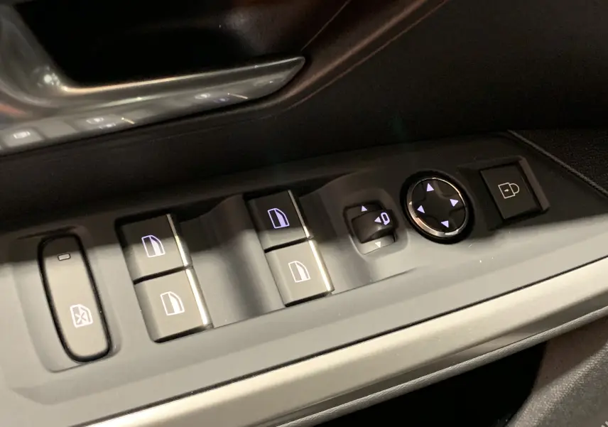 Gros plan sur les commandes des vitres et rétroviseurs côté gauche du Peugeot 3008 III GT Hybrid 136 e-DSC6, intérieur noir.