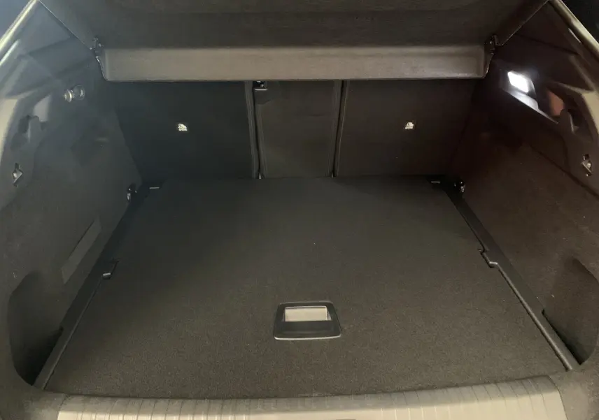 Coffre spacieux et noir du Peugeot 3008 III GT Hybrid 136 e-DSC6 vu de l'arrière avec cache-bagages relevé.