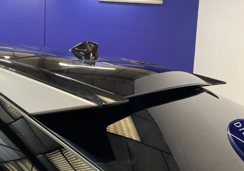 Gros plan sur l'antenne requin et l'aileron arrière du Peugeot 3008 III GT HYBRID gris Artense, vue de dessus arrière.