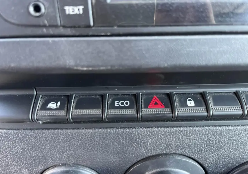Gros plan sur les boutons de commande du tableau de bord du Renault Master blanc, avec touche ECO et alerte triangle rouge.