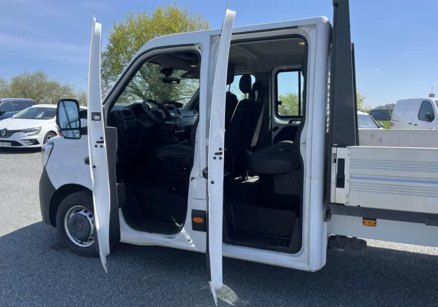 Vue latérale gauche d'un Renault Master blanc 2020 avec portes ouvertes montrant la cabine double et le plateau ridelles.