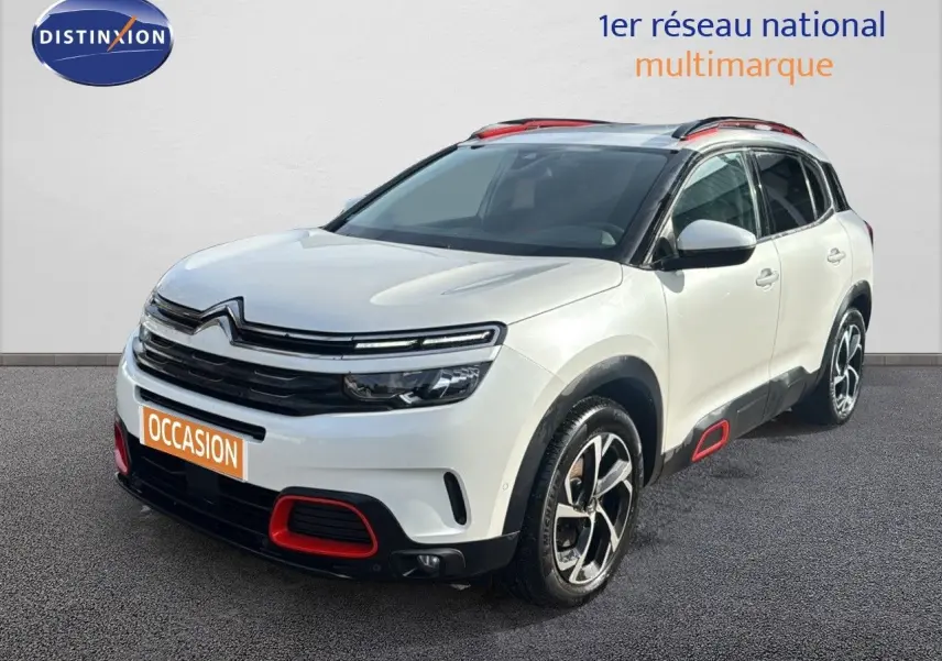 Citroën C5 Aircross blanc nacré en 3/4 avant droit, avec détails rouges sur boucliers et bas de caisse.