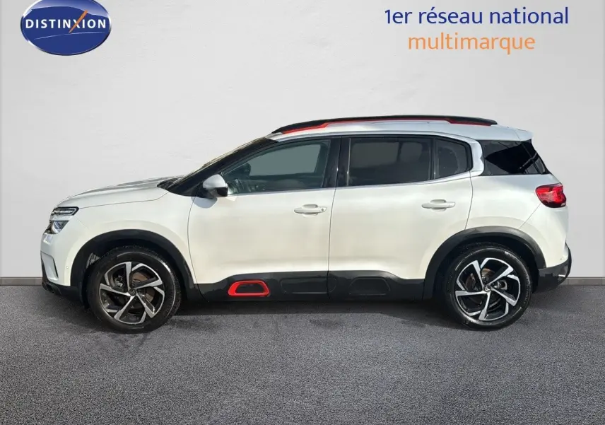 Profil côté gauche d'un Citroën C5 Aircross blanc nacré avec inserts rouges et jantes alliage distinctives.