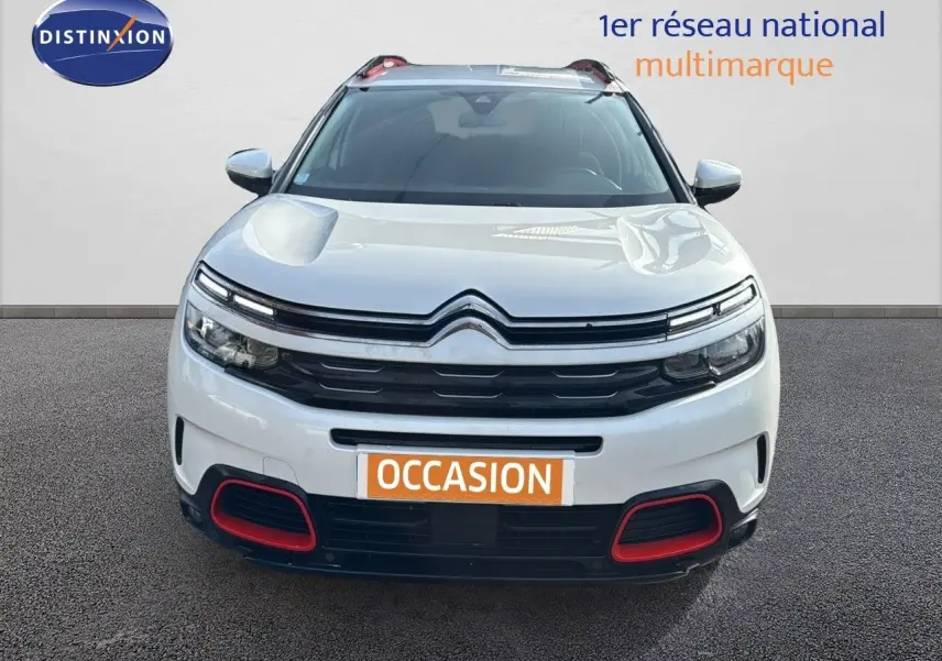 Citroën C5 Aircross blanc nacré en vue frontale, avec détails rouges sur le pare-chocs et calandre noire.