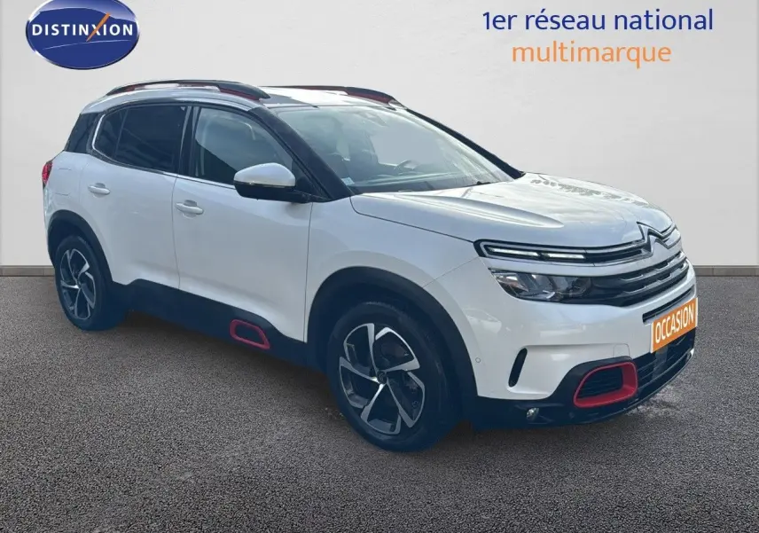 Citroën C5 Aircross blanc nacré en 3/4 avant droit avec détails rouges sur boucliers et bas de caisse.