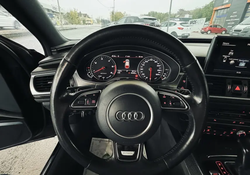 Vue centrée sur le volant noir de l'Audi A6 Allroad 2016, avec tableau de bord digital et commandes éclairées en rouge.