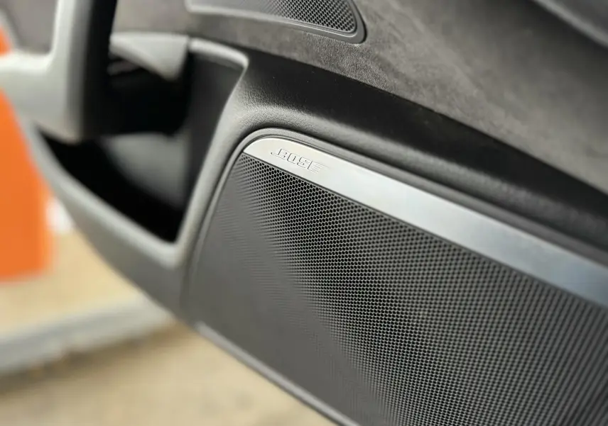Gros plan sur l'enceinte Bose intégrée à la porte intérieure noire de l'Audi A6 Avant Allroad 2016.