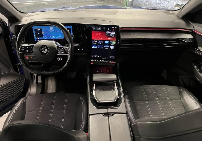 Vue intérieure avant du Renault Austral 2023 bleu, tableau de bord numérique et écran tactile vertical au centre.