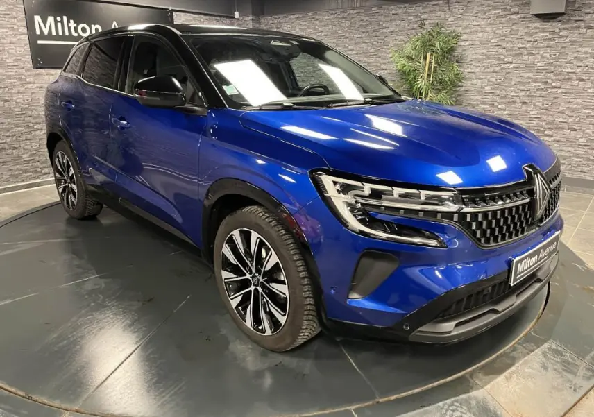 Renault Austral bleu Iron en 3/4 avant droit avec calandre damier chrome sombre et jantes alliage noires diamantées