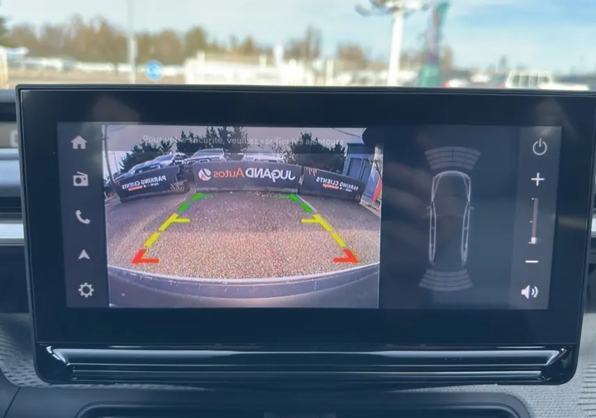 Écran tactile intérieur montrant la caméra de recul et les capteurs de stationnement d'une Citroën C3 Aircross hybride 2025.