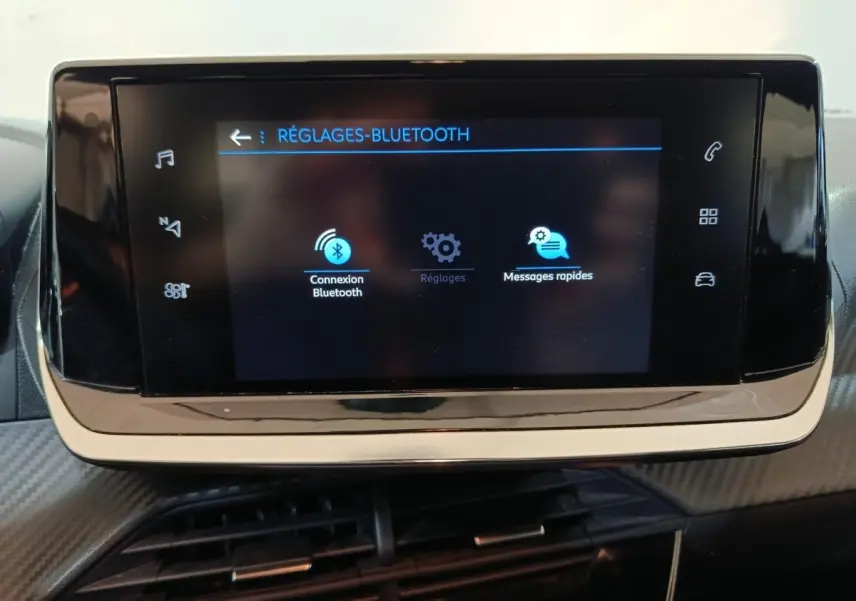 Écran tactile central affichant les réglages Bluetooth dans l'habitacle noir de la Peugeot 208 1.2 PT 75 S&S Premium.