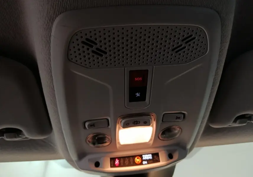 Vue intérieure du plafonnier avant de la Peugeot 208 noir 2022 avec bouton SOS et éclairage allumé.