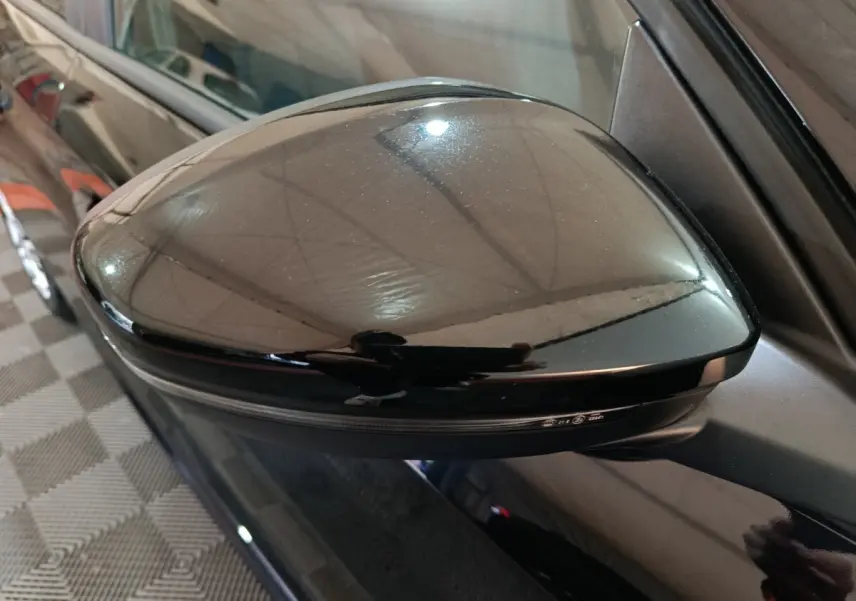 Rétroviseur côté gauche noir brillant de la Peugeot 208 1.2 PT 75 S&S Premium vue en gros plan.