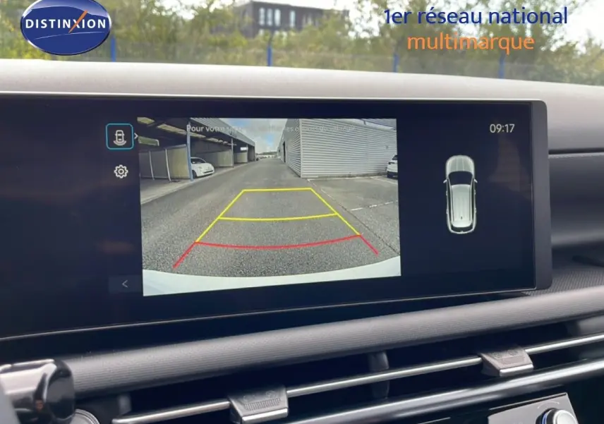 Écran intérieur du Hyundai Tucson blanc Atlas 2026 montrant la caméra de recul avec lignes de guidage colorées.