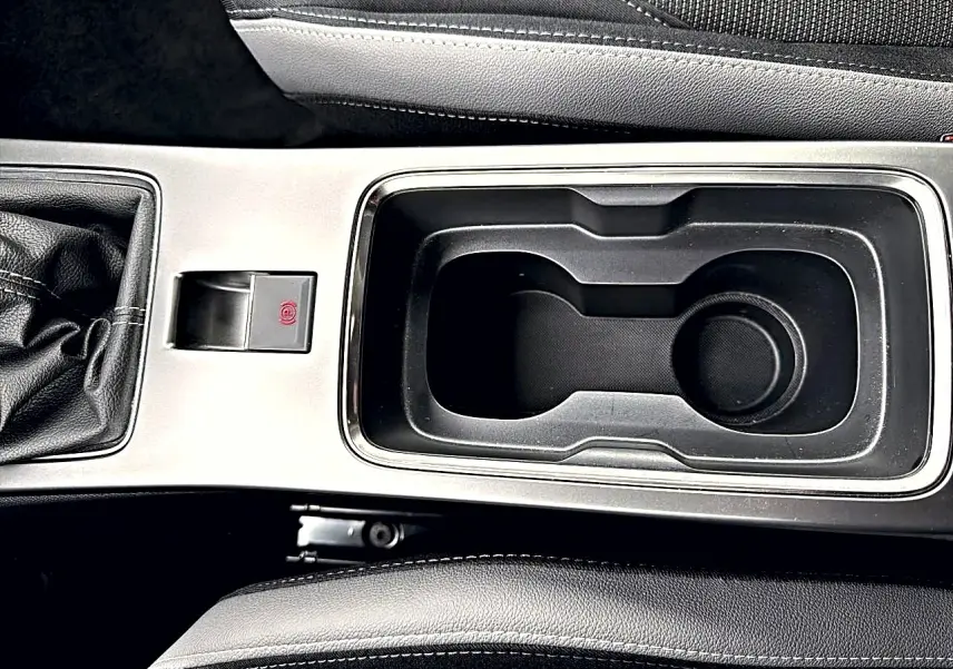 Vue rapprochée de la console centrale noire et argentée de l'Opel Mokka 1.2 turbo 136 edition avec levier de vitesse manuel.