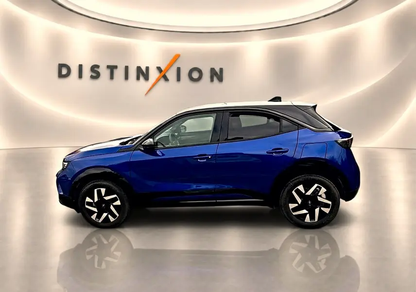 Opel Mokka bleu en profil droit, toit noir contrastant et jantes au design moderne en showroom lumineux.