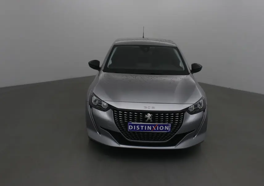 Peugeot 208 gris Artense vue de face avec calandre noire et logo lion distinctif sur fond neutre.