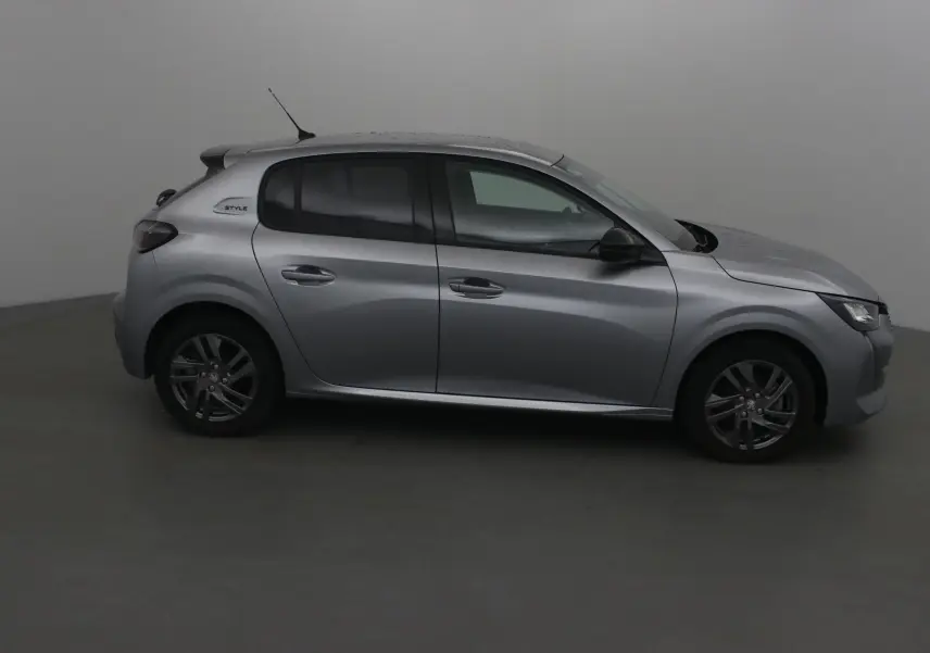 Profil droit d'une Peugeot 208 gris Artense 2022 version 1.2 PureTech 100 Style avec jantes alliage et vitres teintées.