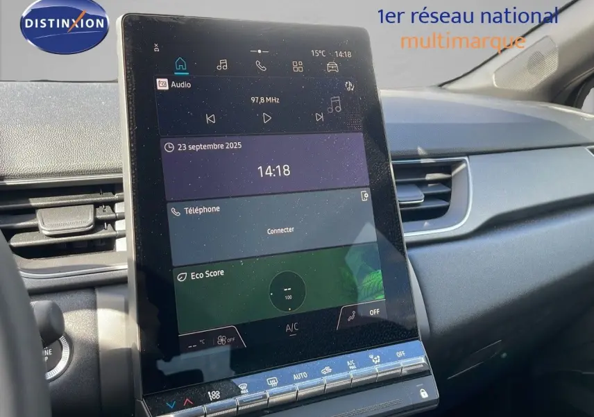 Écran tactile central en gros plan de la Renault Captur E-Tech hybride 2025, intérieur gris et noir visible côté passager.