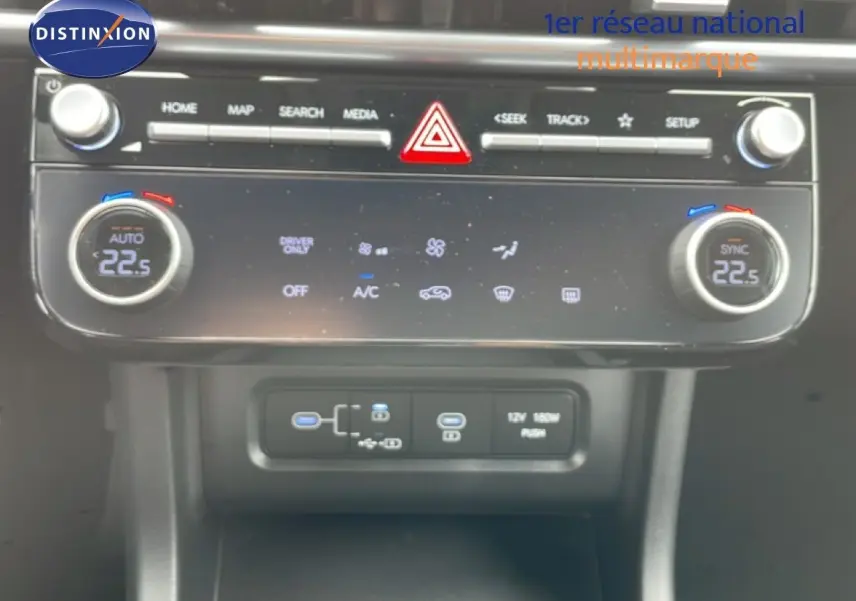Gros plan sur la console centrale du Hyundai Tucson blanc Atlas 2026, mettant en valeur les commandes de climatisation et ports USB.