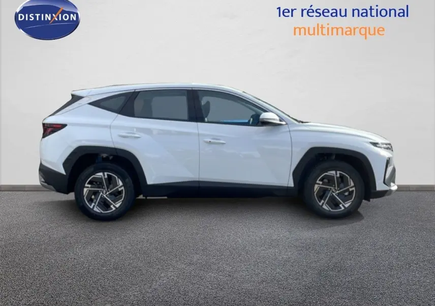 Profil droit du Hyundai Tucson blanc Atlas 2026 avec jantes bi-ton et lignes anguleuses marquées.