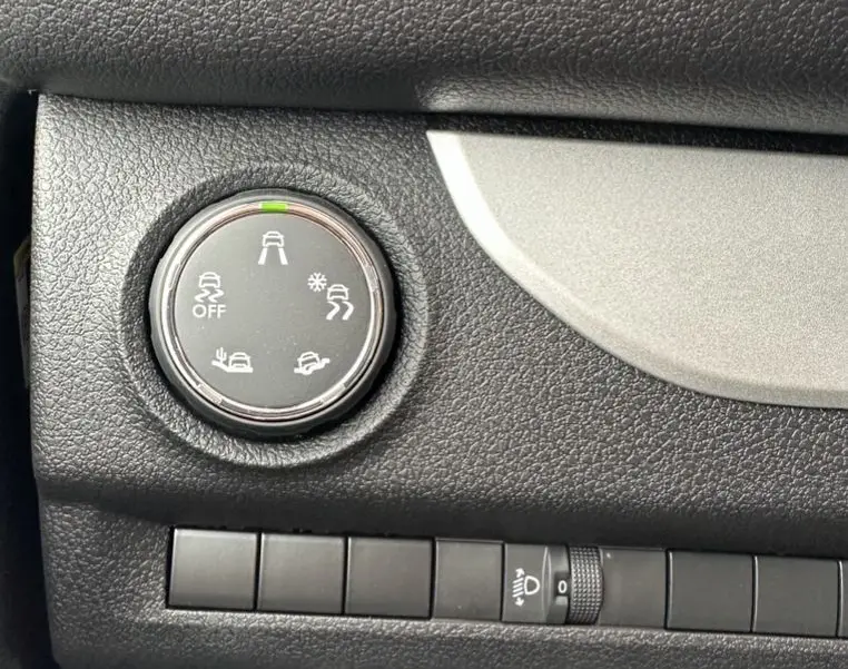 Gros plan sur le bouton de sélection des modes de conduite du tableau de bord noir du Citroën Jumpy van blanc électrique.