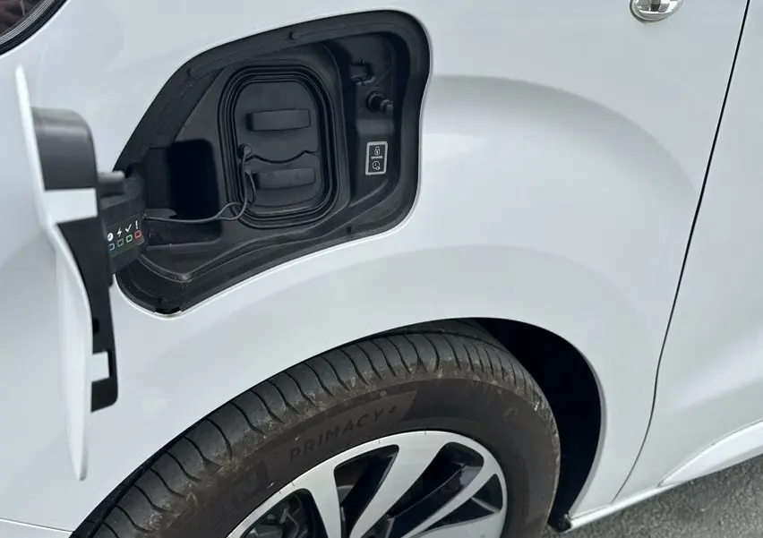 Gros plan sur la trappe de recharge ouverte côté avant gauche d’un Citroën Jumpy van blanc avec jante aluminium 17 pouces.